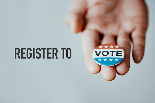 the text register to vote, with a vote badge in the hand of a man