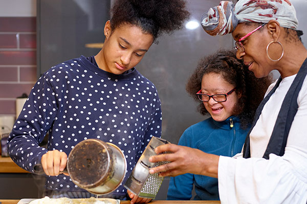 A mother with her two daughters cooking