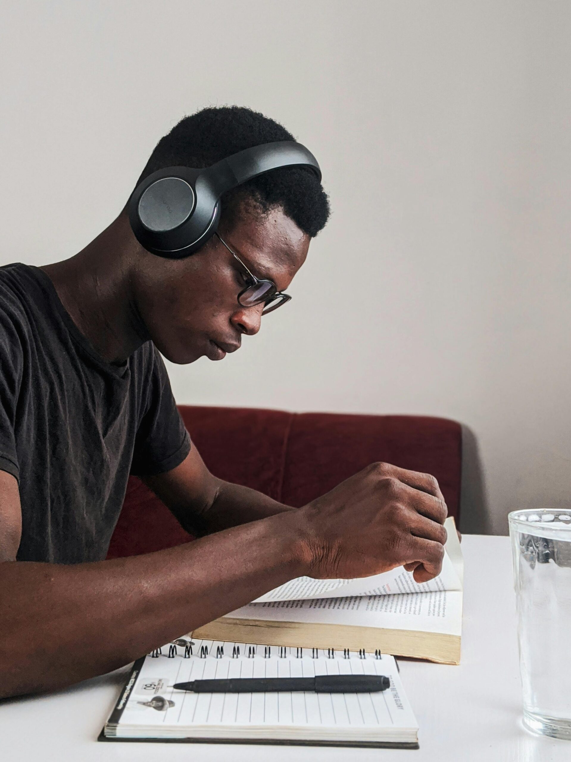 a young adult listening to music and reading a book