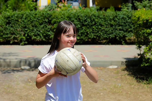 girl with autism holding a ball